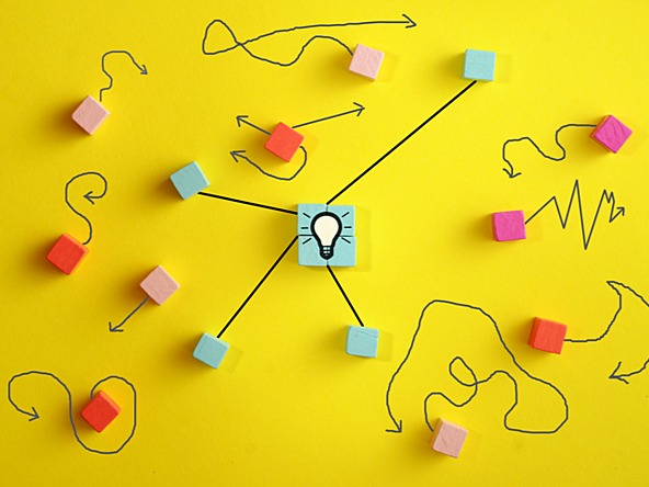 lightbulb against yellow background, with colourful squares and lines